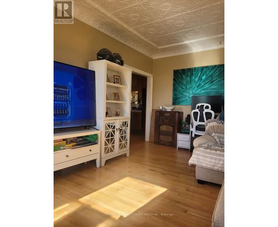 A living room with a TV, a couch, and a bookshelf.