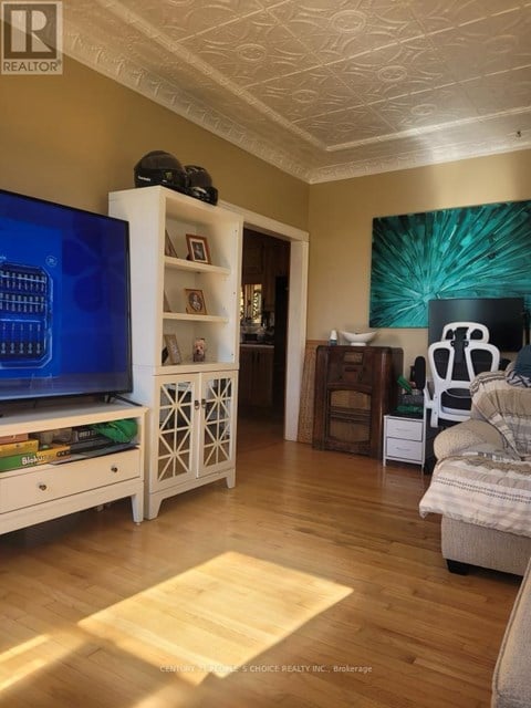 A living room with a TV, a couch, and a bookshelf.