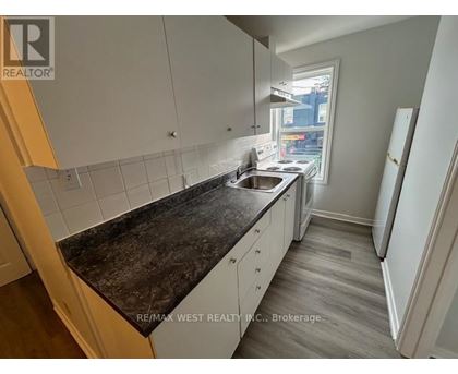 A kitchen with white cabinets and a black countertop.