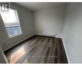 A room with a window and a wooden floor.