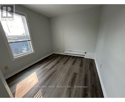 A room with a window and a wooden floor.