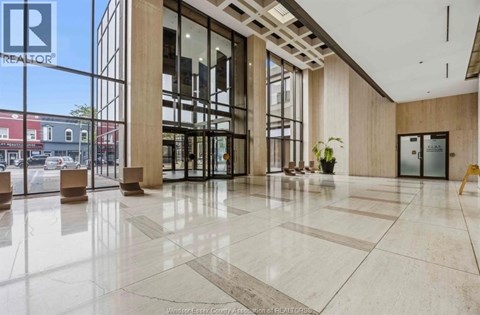 A large, well-lit lobby with a marble floor and a glass wall overlooking the street.
