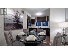 A dining room with a table set for two and a large landscape picture on the wall.