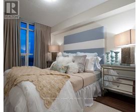 A bedroom with a bed, nightstand, and lamp.