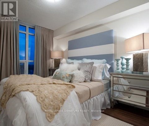 A bedroom with a bed, nightstand, and lamp.
