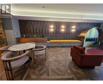 A room with a wooden floor and a bench with a backrest.