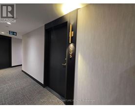 A hallway with a door on the right and a sign on the wall.