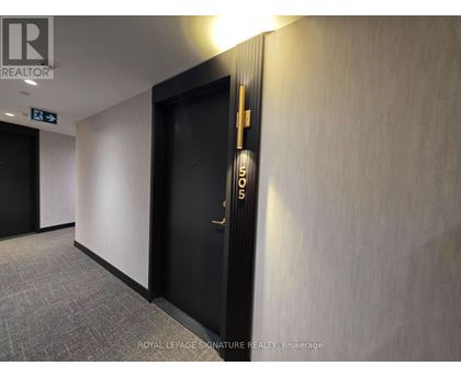 A hallway with a door on the right and a sign on the wall.
