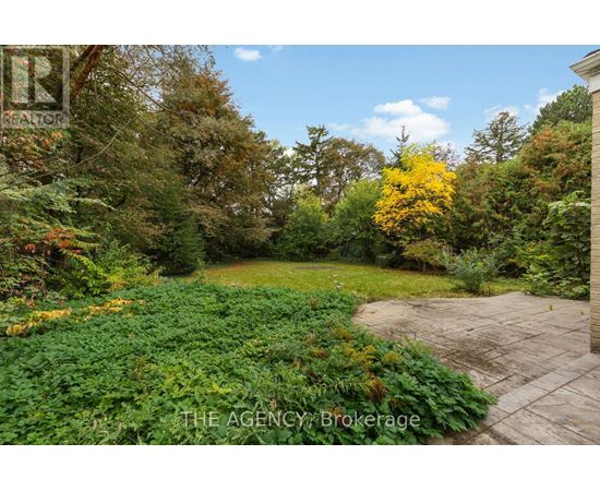 A garden with a brick pathway and a variety of plants and trees.
