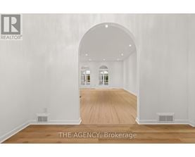 A spacious room with a wooden floor and white walls.