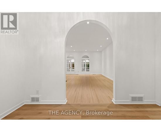 A spacious room with a wooden floor and white walls.