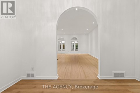 A spacious room with a wooden floor and white walls.