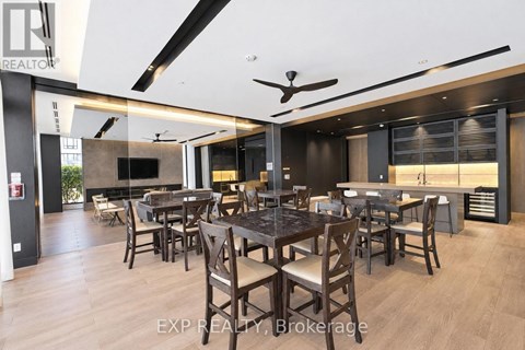 A modern dining room with a dark wood table and chairs.