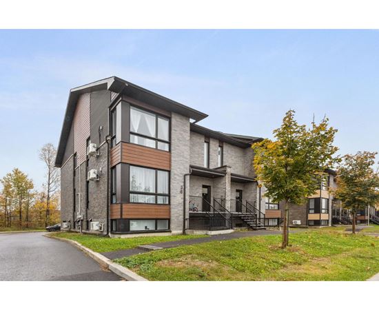 A modern two-story house with a black metal staircase.