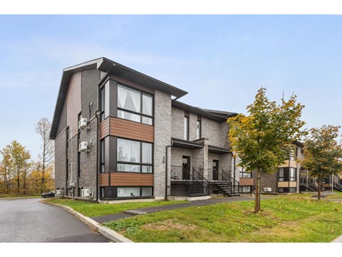 A modern two-story house with a black metal staircase.