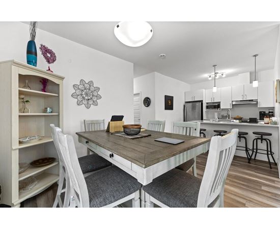 A dining room with a table and chairs.