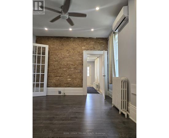 A room with a brick wall and wooden floors.