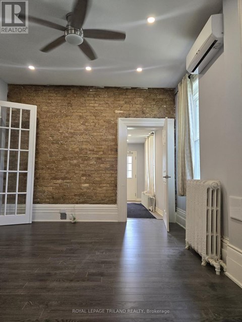A room with a brick wall and wooden floors.