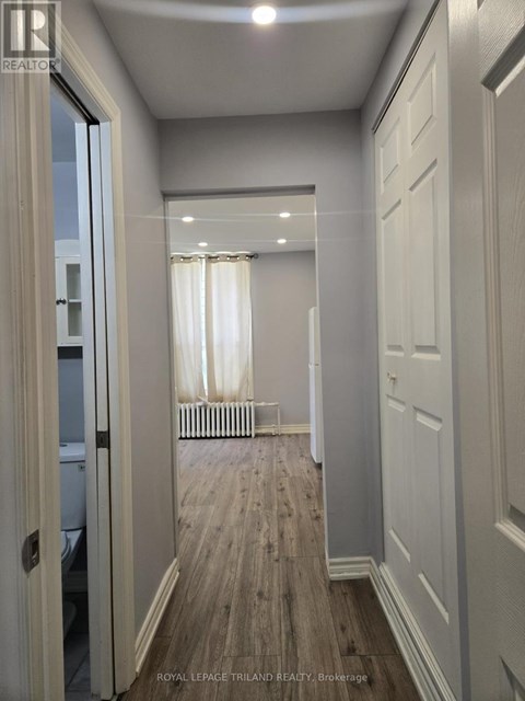 A hallway with white doors and a wooden floor.