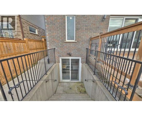 A small balcony with a metal railing and a glass door.