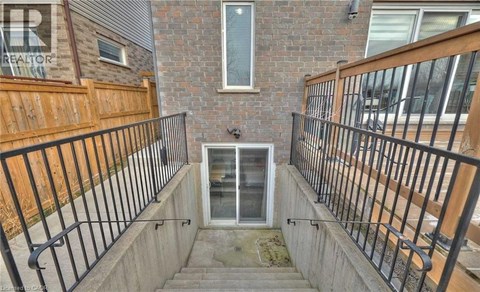 A small balcony with a metal railing and a glass door.