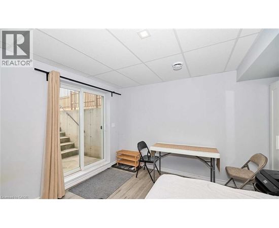 A room with a bed, a table and chairs, and a sliding glass door.