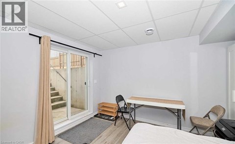A room with a bed, a table and chairs, and a sliding glass door.