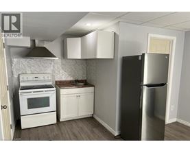 A kitchen with a stainless steel refrigerator, oven, and cabinets.