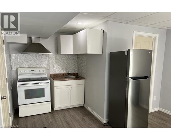 A kitchen with a stainless steel refrigerator, oven, and cabinets.
