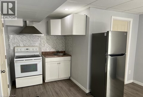 A kitchen with a stainless steel refrigerator, oven, and cabinets.