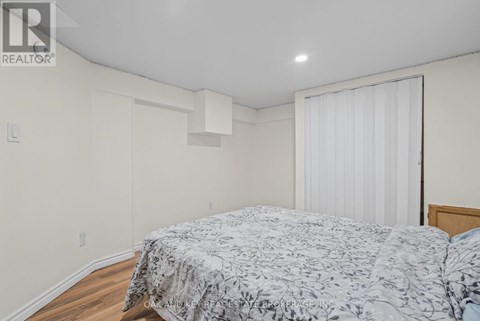 A bedroom with a bed and a window with a white curtain.