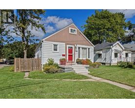 A small house with a red door is for sale.