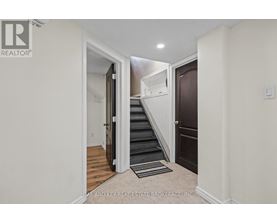 A hallway with a staircase leading to the second floor.