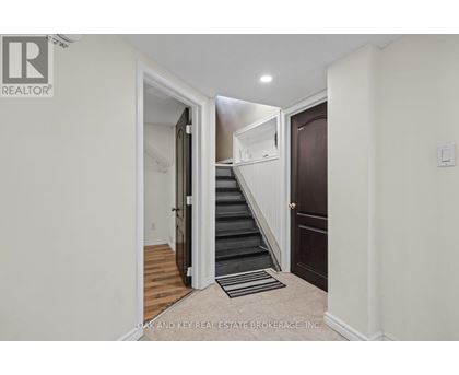 A hallway with a staircase leading to the second floor.