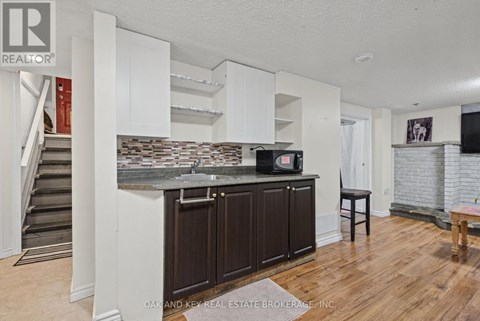 A kitchen with white cabinets and a countertop with a microwave and oven.