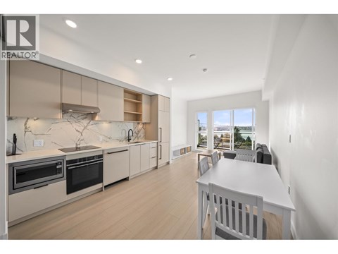 A modern kitchen with a dining table and chairs.