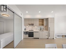 A modern kitchen with white cabinets and appliances.