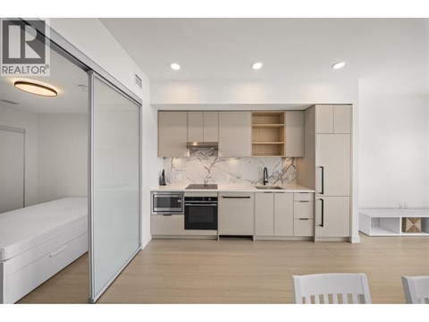 A modern kitchen with white cabinets and appliances.