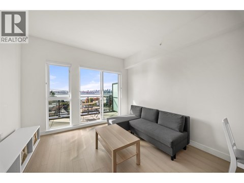 A living room with a grey couch and a wooden coffee table.