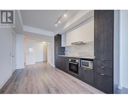 A modern kitchen with wooden cabinets and a marble backsplash.