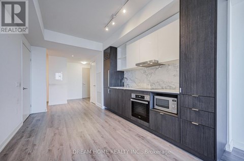 A modern kitchen with wooden cabinets and a marble backsplash.