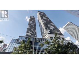 Two modern skyscrapers with glass facades are seen against a blue sky.