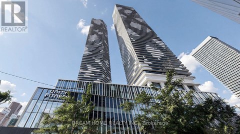 Two modern skyscrapers with glass facades are seen against a blue sky.