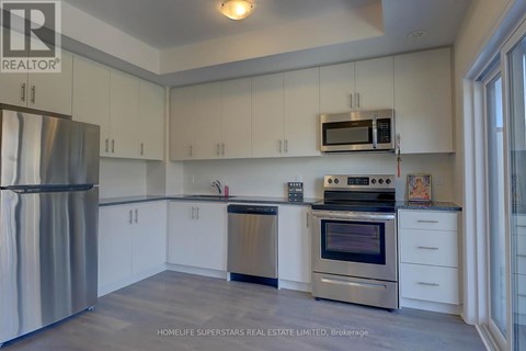 A kitchen with white cabinets and stainless steel appliances.