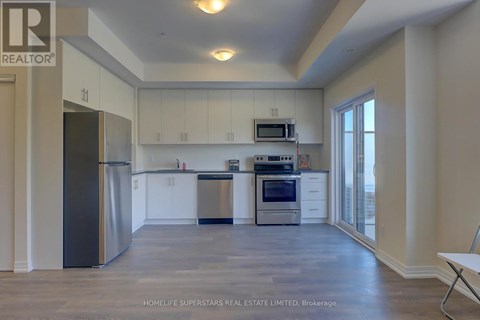 A spacious kitchen with white cabinets and stainless steel appliances.