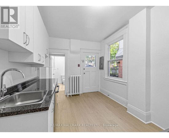 A kitchen with white cabinets and a black countertop.