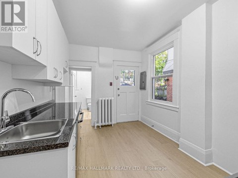 A kitchen with white cabinets and a black countertop.