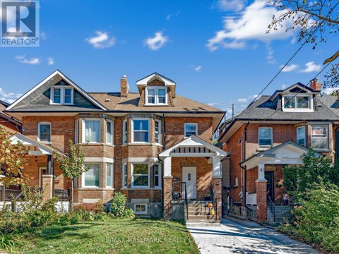 A large brick house with a white entrance and a small porch.