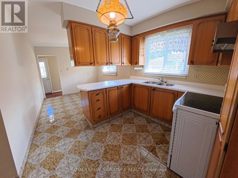 A kitchen with wooden cabinets and a checkered floor.