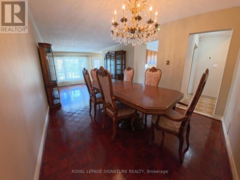 A dining room with a chandelier and a table with chairs.